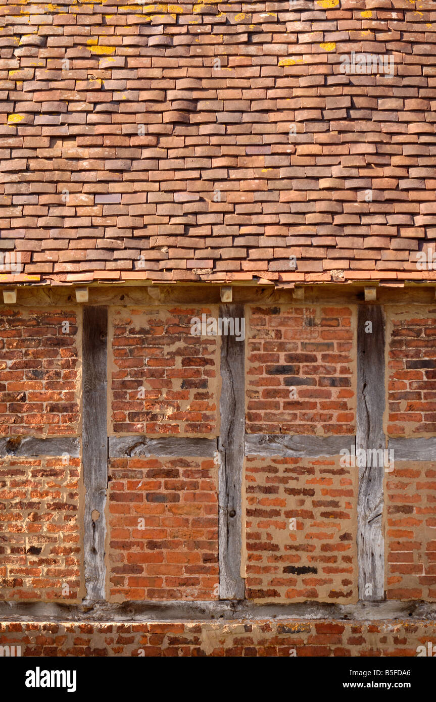 DETAIL OF A RED BRICK AND TIMBER FRAMED BARN WITH CLAY TILED ROOF IN
