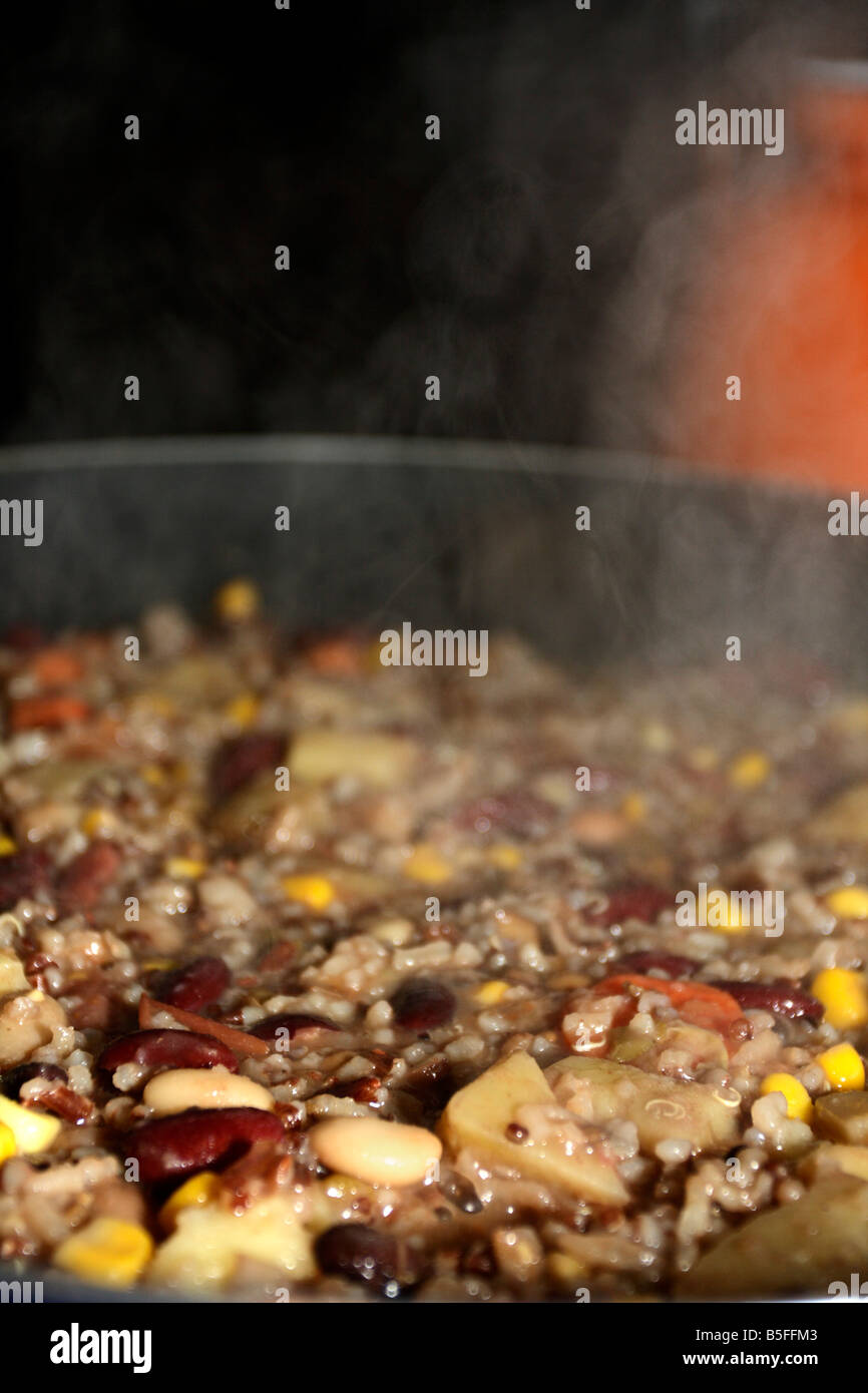 Red, white, and lentil beans, rice, potatoes, corn, quinoa, and corn steaming in skillet. Stock Photo