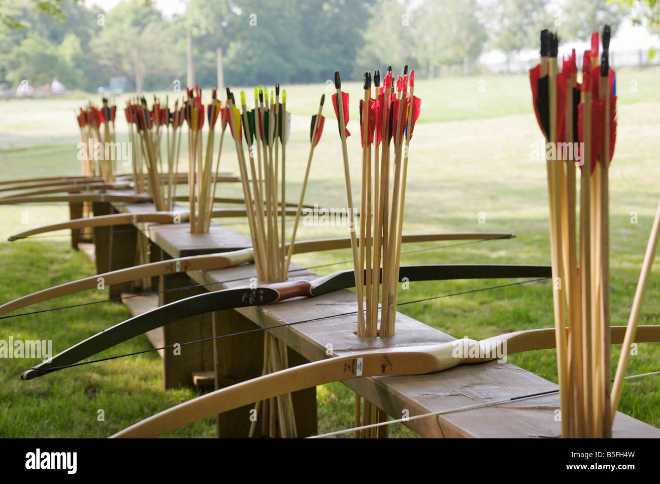 A Row Of Longbows And Arrows With Colorful Feathers In A Wooden Bench A Row Of Longbows And Arrows With Colorful Feathers In A Wooden Bench