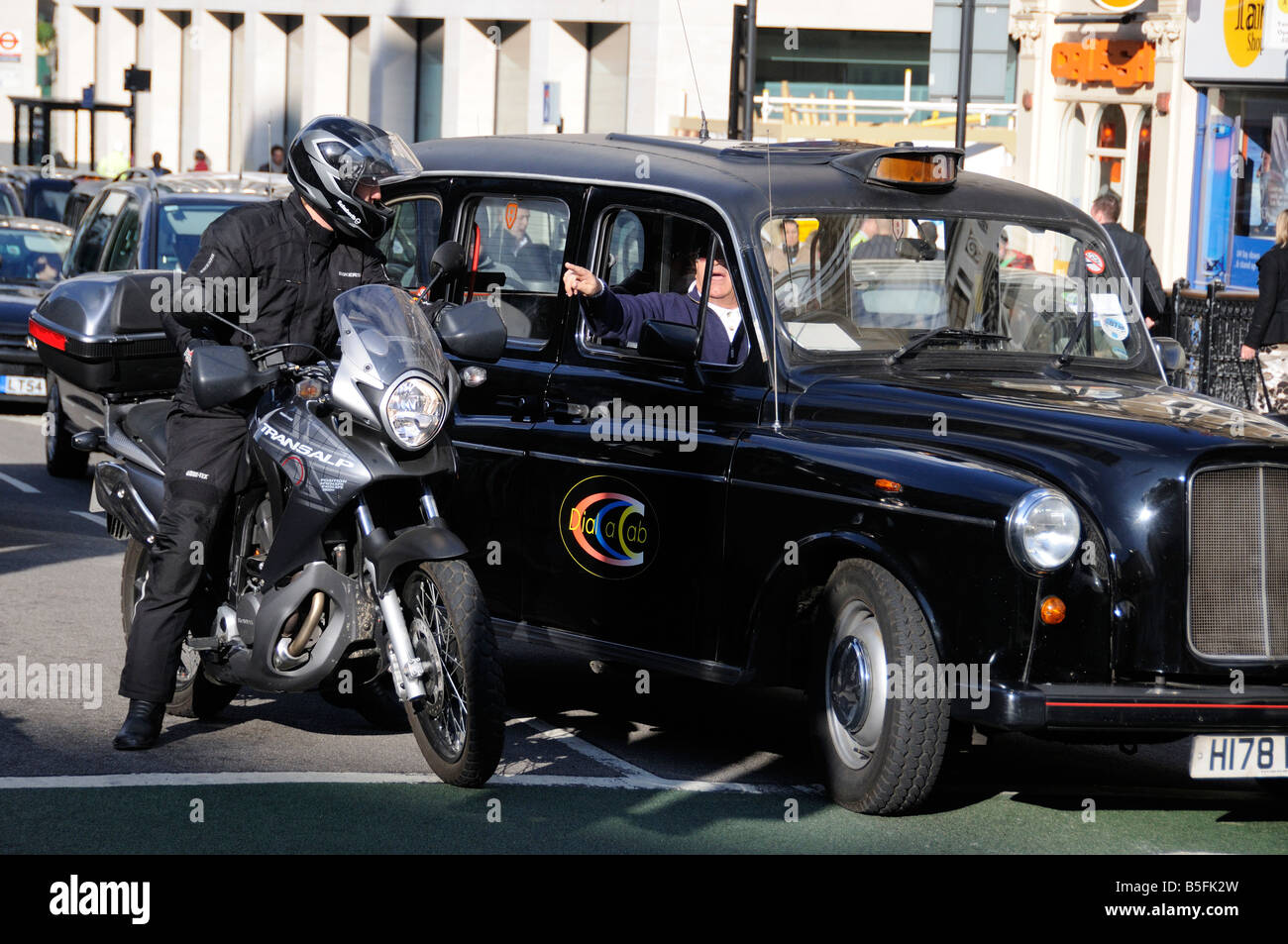 A taxi driver giving directions to a motorcyclist, Ludgate Circus, London, UK Stock Photo