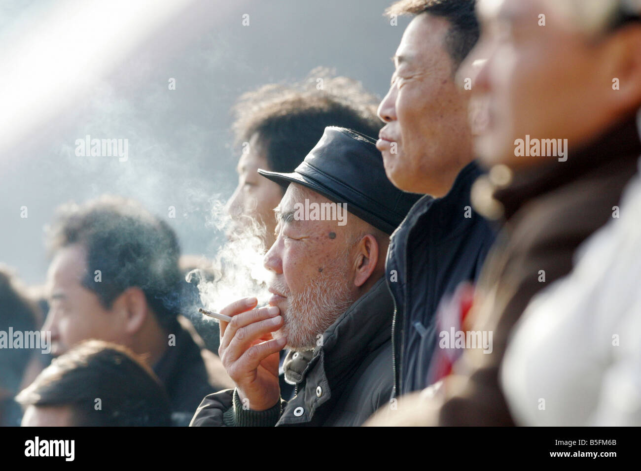 Men at horse races, one smoking a cigarette, Seoul, South Korea Stock