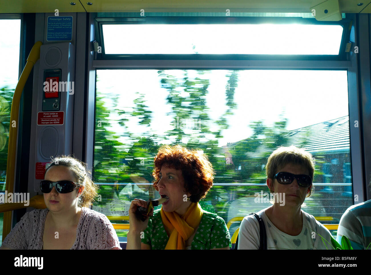 Woman with red hair on a tram eating an ice cream Stock Photo