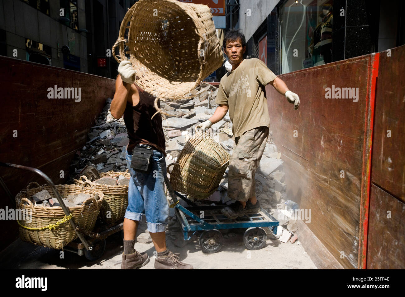 Workers unload construction waste in Hong Kong, China. Stock Photo