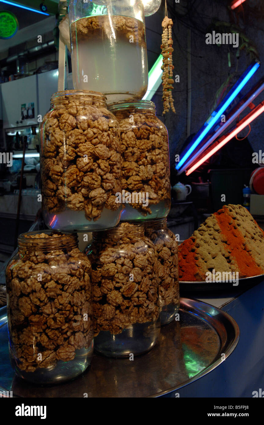 Pickled walnuts for sale displayed in a pyramid of jars iran Stock
