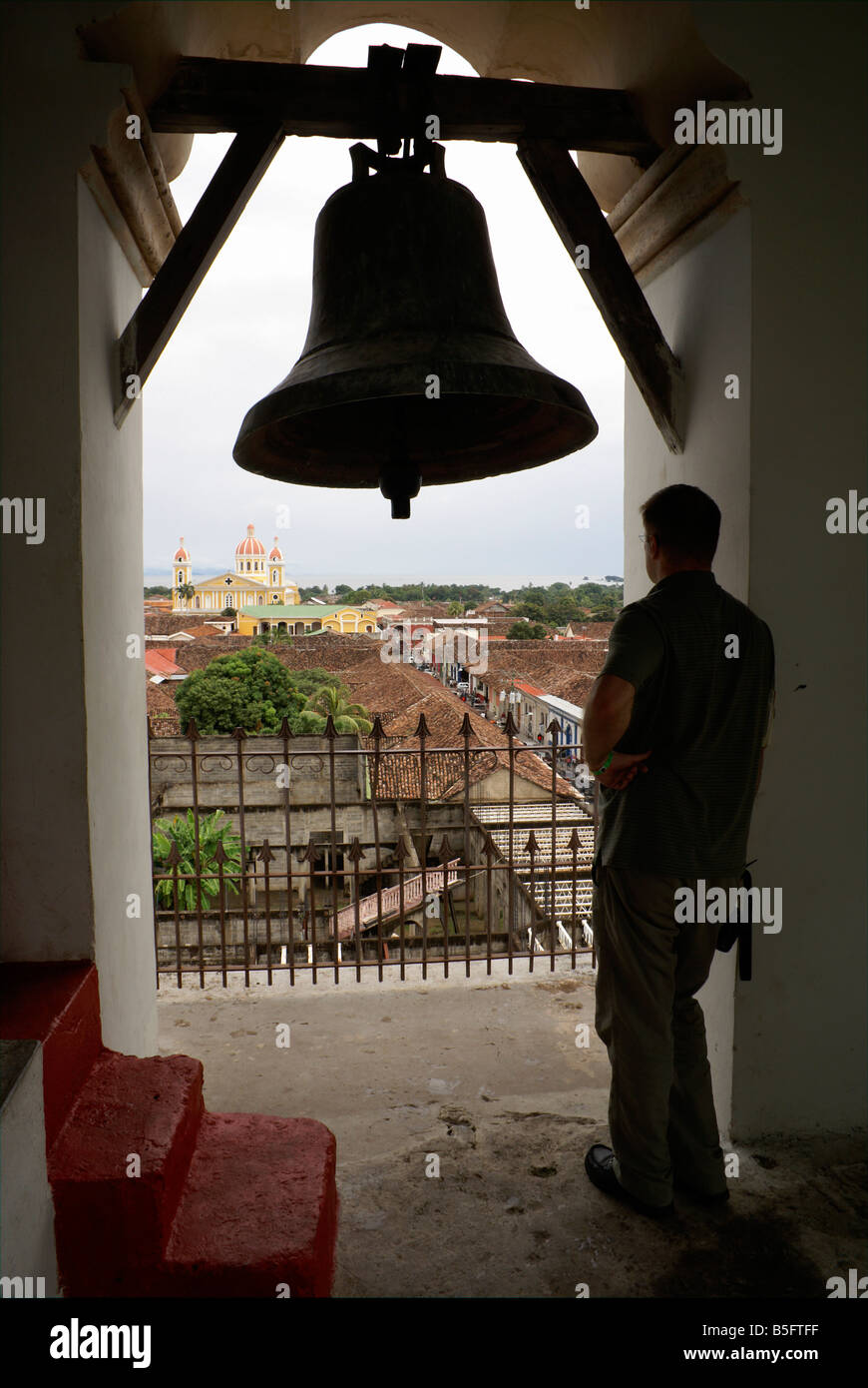 Tourist admiring the view of the Spanish colonial city of Granada from the bell tower of La Merced Church, Granada, Nicaragua Stock Photo