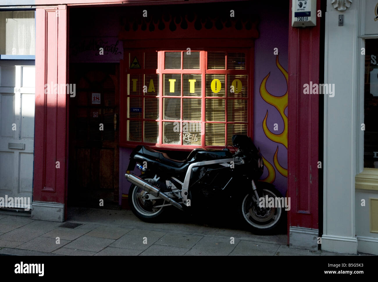 Tattoo parlour and motorbike Stock Photo