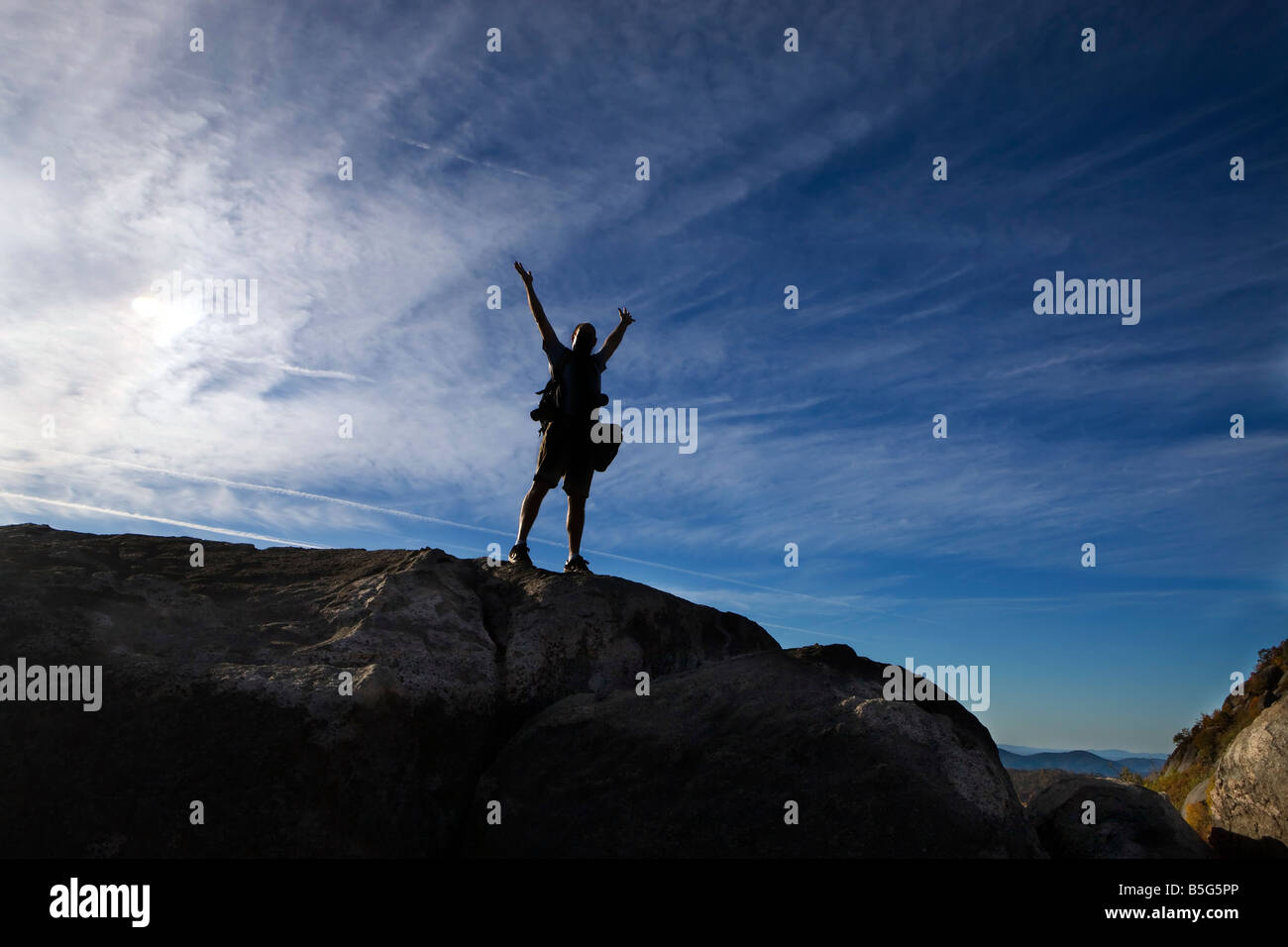 Silohuette of a man with arms raised above his head against a deep blue sky Old Rag Mountain  Shenandoah National Park, VA Stock Photo