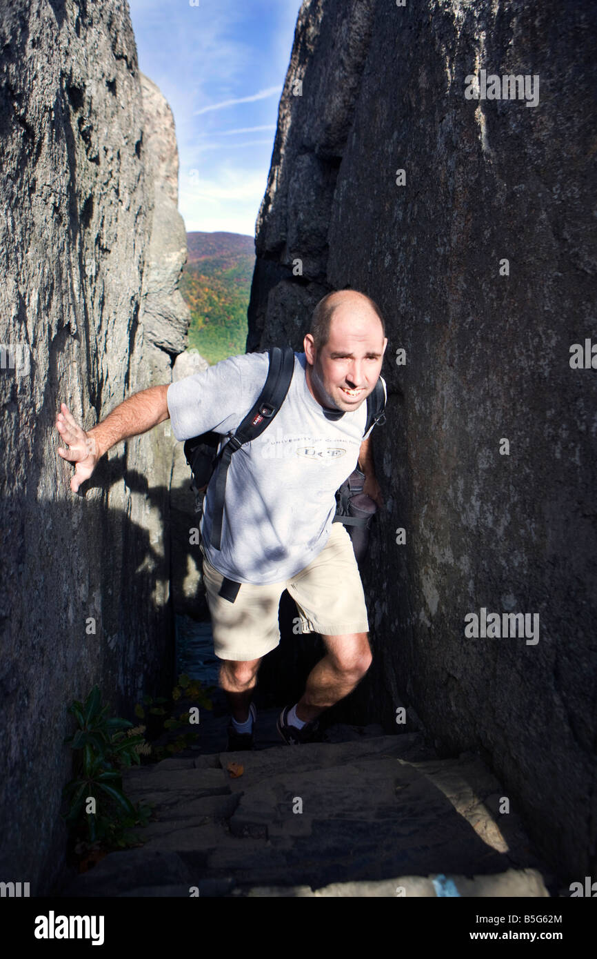 Male hiker ascending a rock climb up a narrow passage between two granite rocks, Old Rag Mountain, Shenandoah National Park, Virginia. Stock Photo