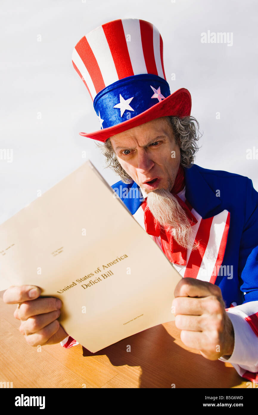 Uncle Sam sitting at a table looking surprised and astounded as he reads the United States deficit bill Stock Photo