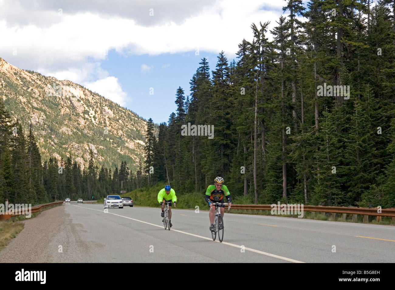 Bicyclists riding on Washington State Highway 20 in the North Cascade Range Washington Stock Photo