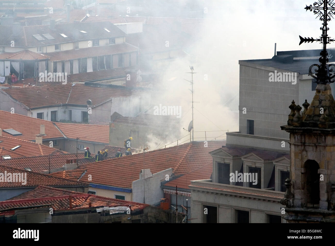 Firefighters on the roof of an apartment on fire in the city of Bilbao Biscay northern Spain Stock Photo