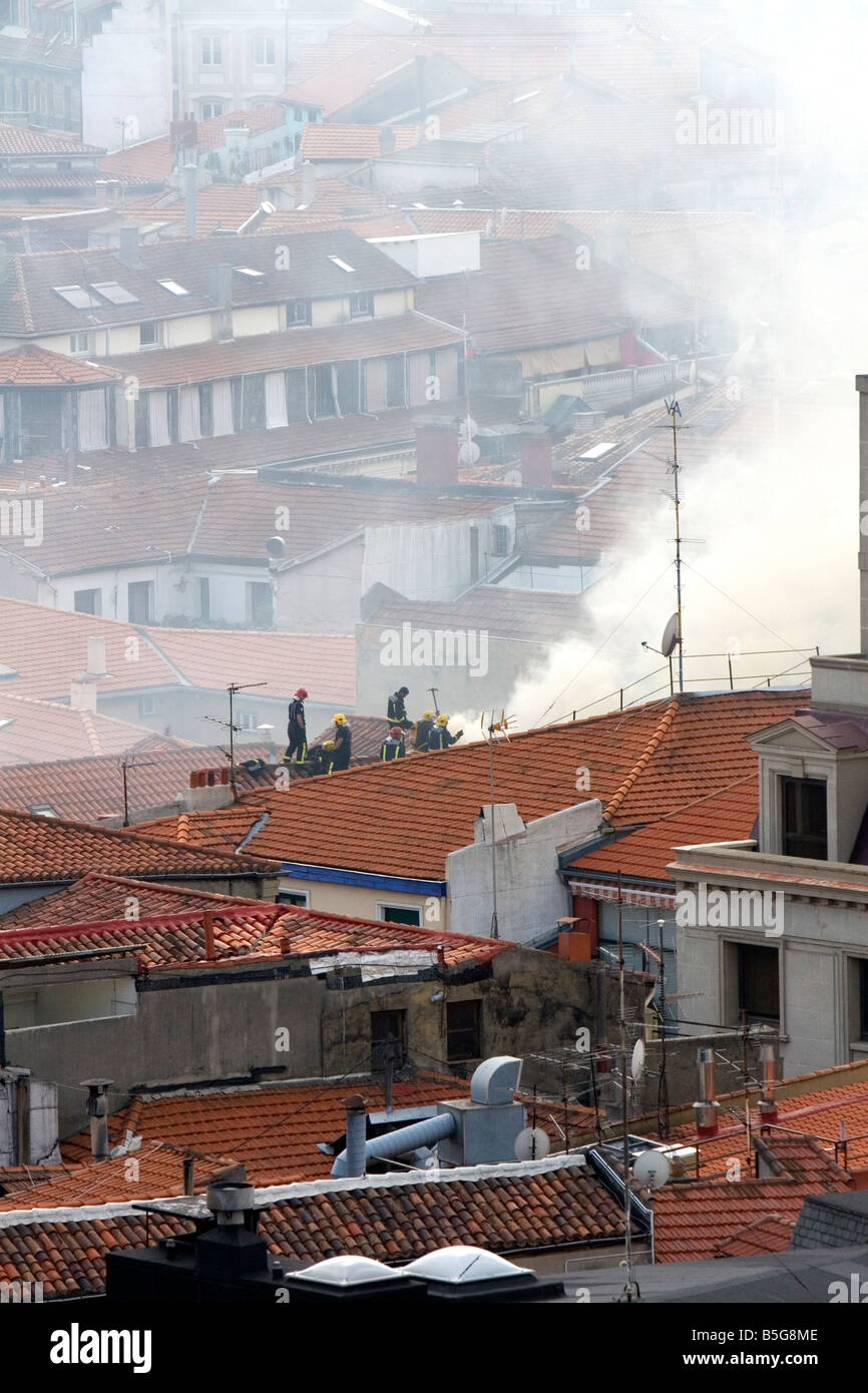 Firefighters on the roof of an apartment on fire in the city of Bilbao Biscay northern Spain Stock Photo