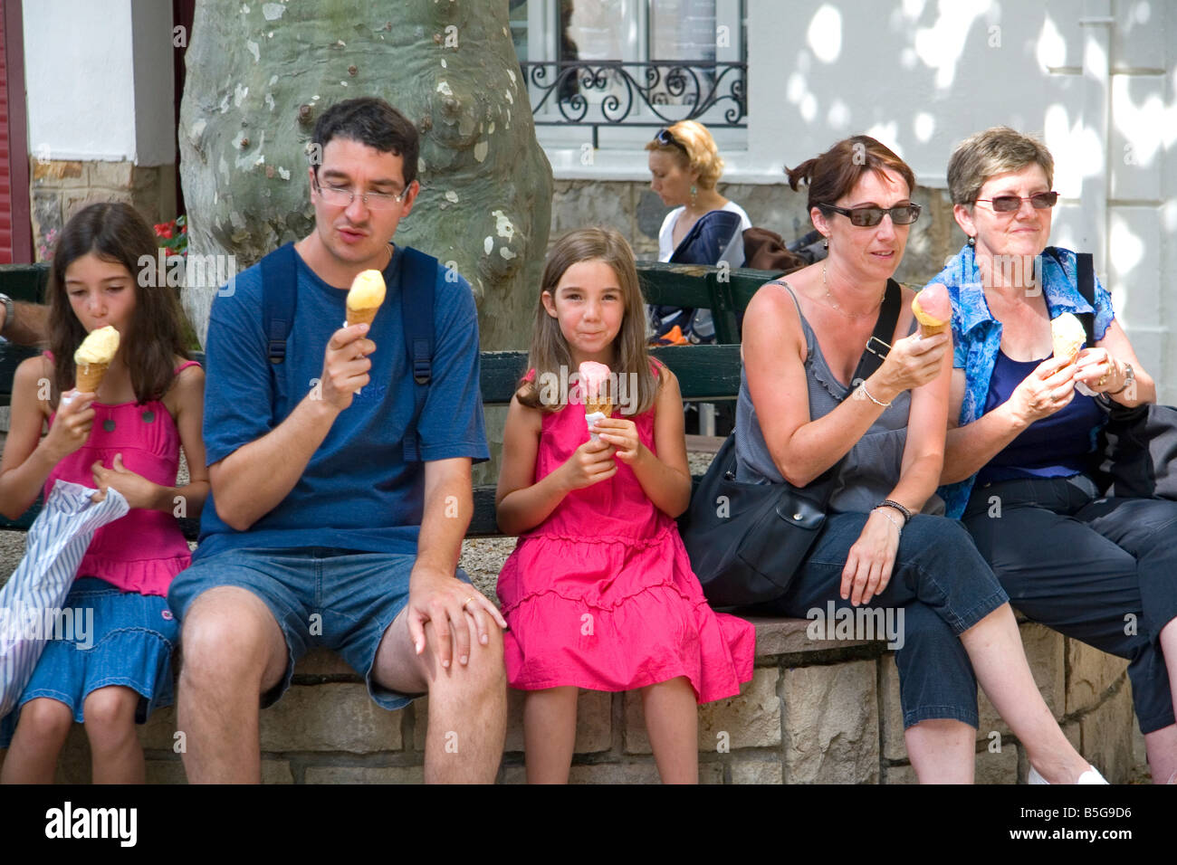 Family eating ice cream in the town of Saint Jean de Luz Pyrenees Atlantiques French Basque Country Southwest France Stock Photo