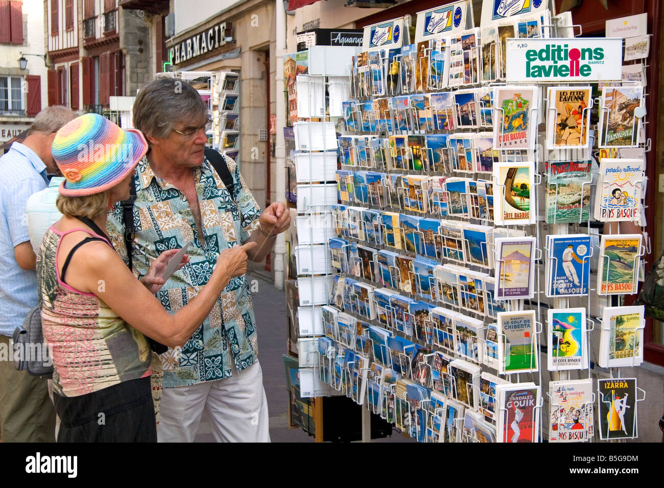 Tourists shop for postcards in the town of Saint Jean de Luz Pyrenees Atlantiques French Basque Country Southwest France Stock Photo