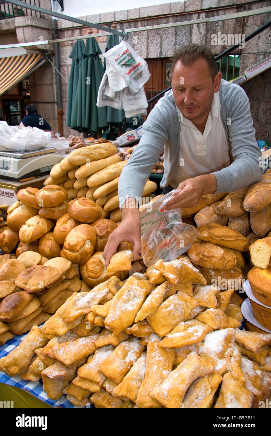 Vendor selling bread and baked goods at an outdoor market in the town of Cangas de Onis Asturias northern Spain Stock Photo