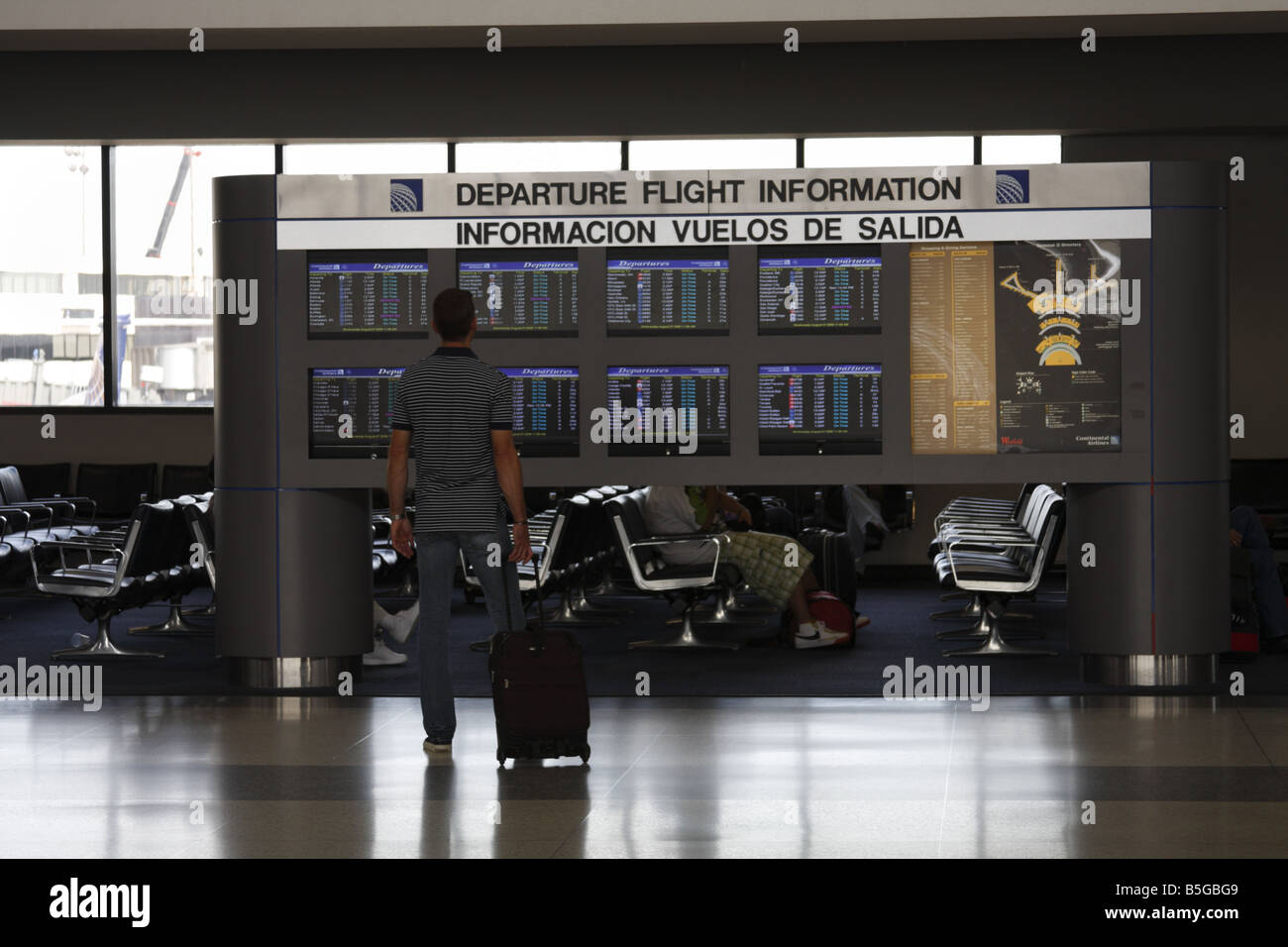 Man looking at the departure flight information board at Houston International Airport, Texas, USA Stock Photo