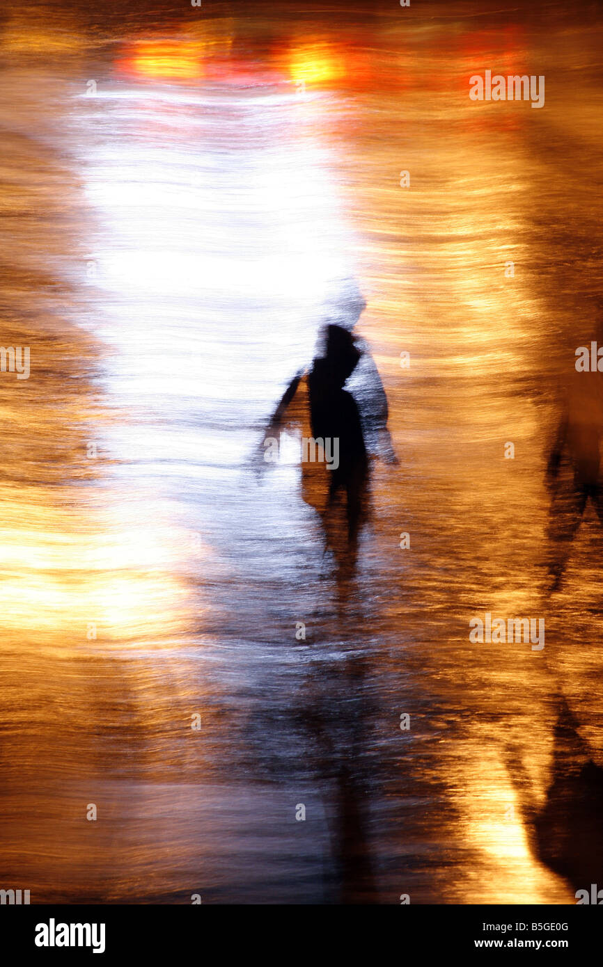 one person walking in heavy rain at night in town Stock Photo