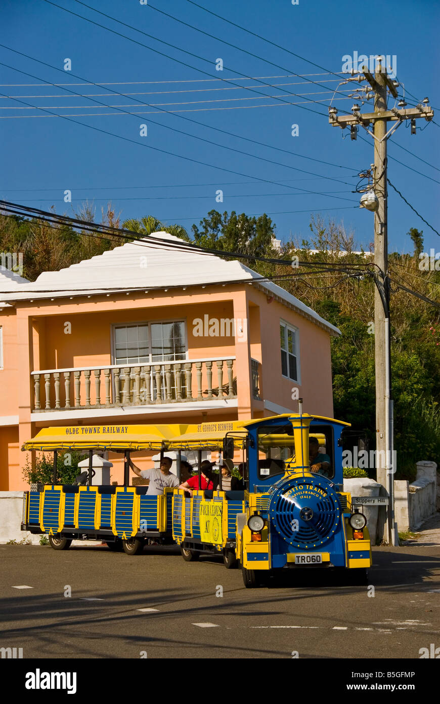 Bermuda St Georges yellow tour train pink house with bright colors Stock Photo