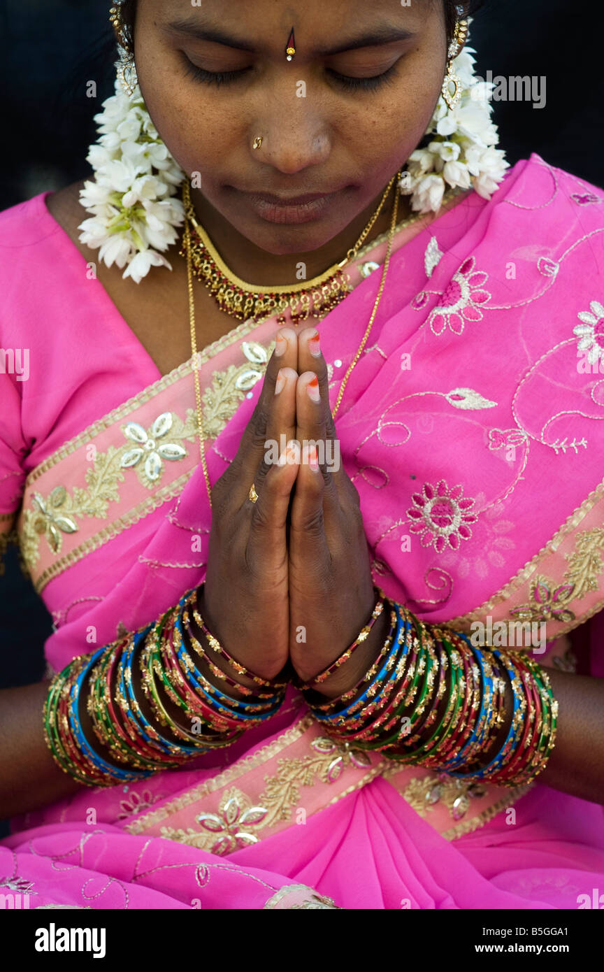 Indian girl wearing pink sari with prayer hands. India Stock Photo