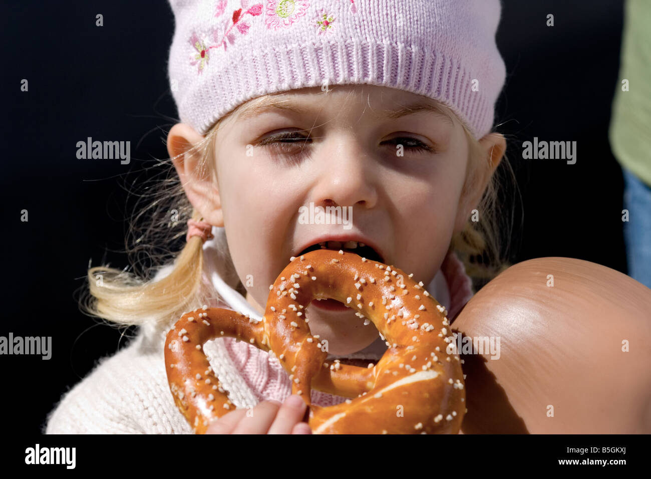 Young child eating a large pretzel Stock Photo Alamy