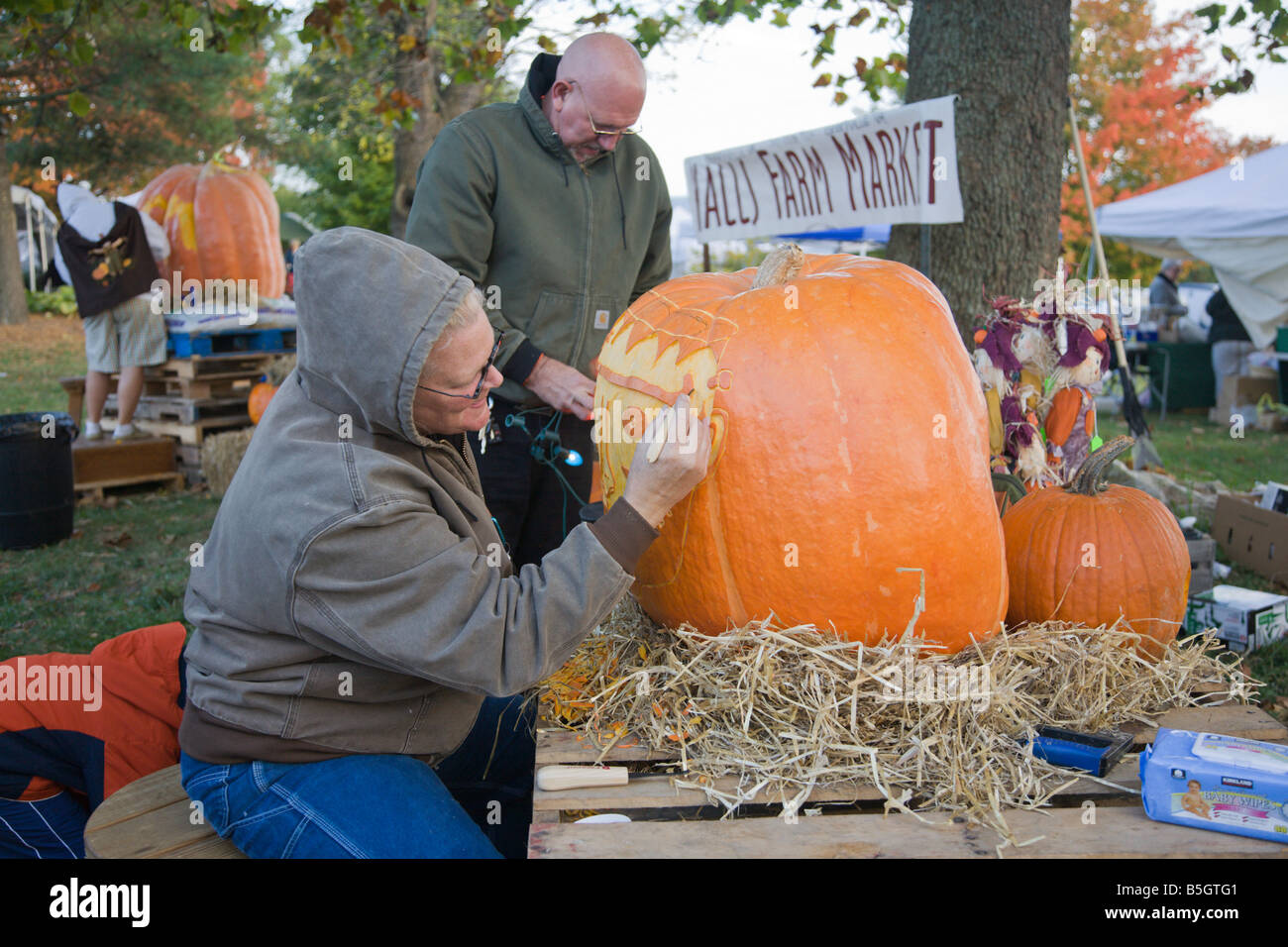 A woman from Nalls Farm Market carves a pumpkin at the 2008 Shenandoah Valley Hot Air Balloon and Wine Festival in Virginia. Stock Photo