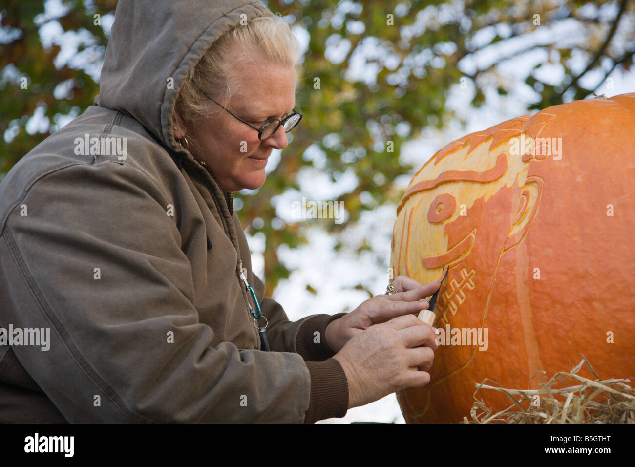 A woman from Nalls Farm Market carves a pumpkin at the 2008 Shenandoah Valley Hot Air Balloon and Wine Festival in Virginia. Stock Photo