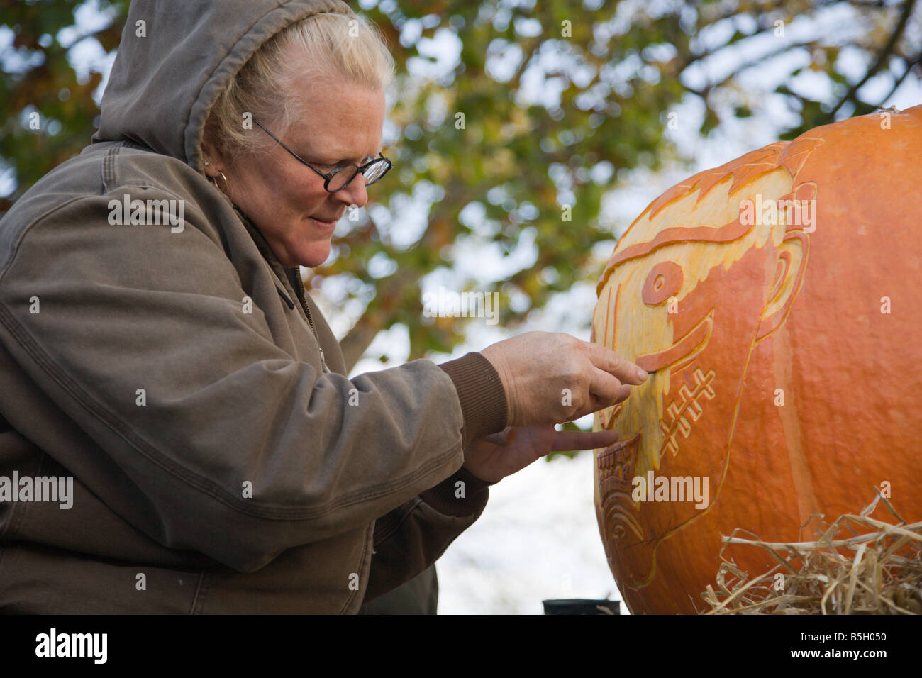 A woman from Nalls Farm Market carves a pumpkin at the 2008 Shenandoah Valley Hot Air Balloon and Wine Festival in Virginia. Stock Photo