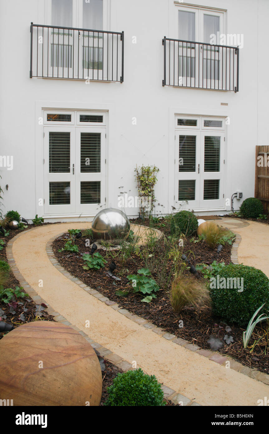 A modern urban designer garden with a spherical theme and a 'pod' seating structure Stock Photo