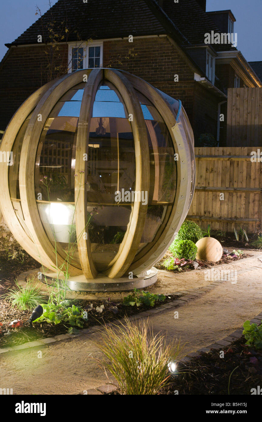 A modern urban designer garden with a spherical theme and a 'pod' seating structure Stock Photo