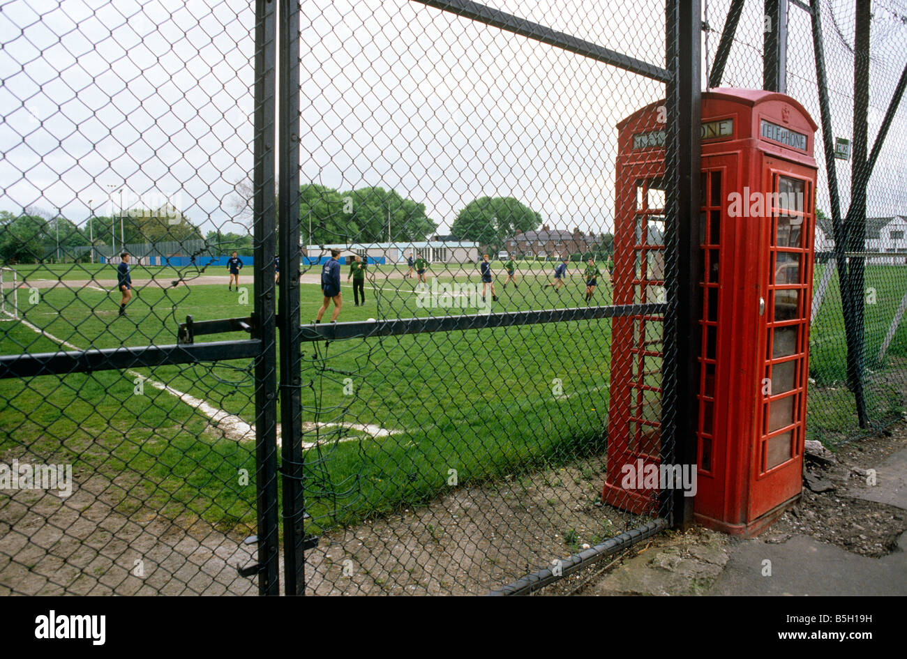 UK England Manchester Rusholme K6 Phone box into Manchester City football clubs Platt Lane Training Ground fence Stock Photo