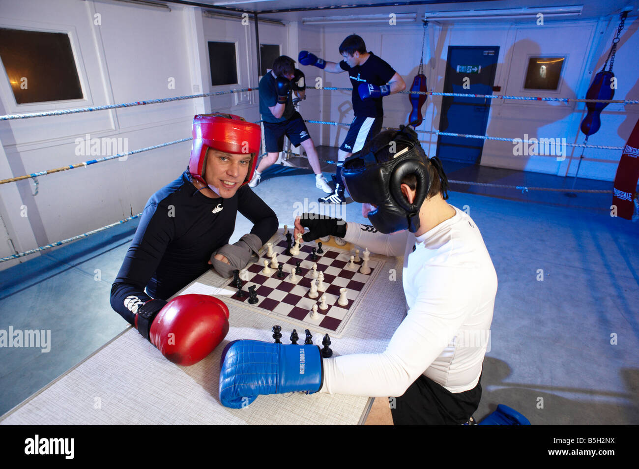 Chess boxers Arik Braun (R) and Felix Bartels sit in front of a chequer  board during the Chess Boxing Championships in Berlin, Germany, 28 July  2012. The chess boxing event took place