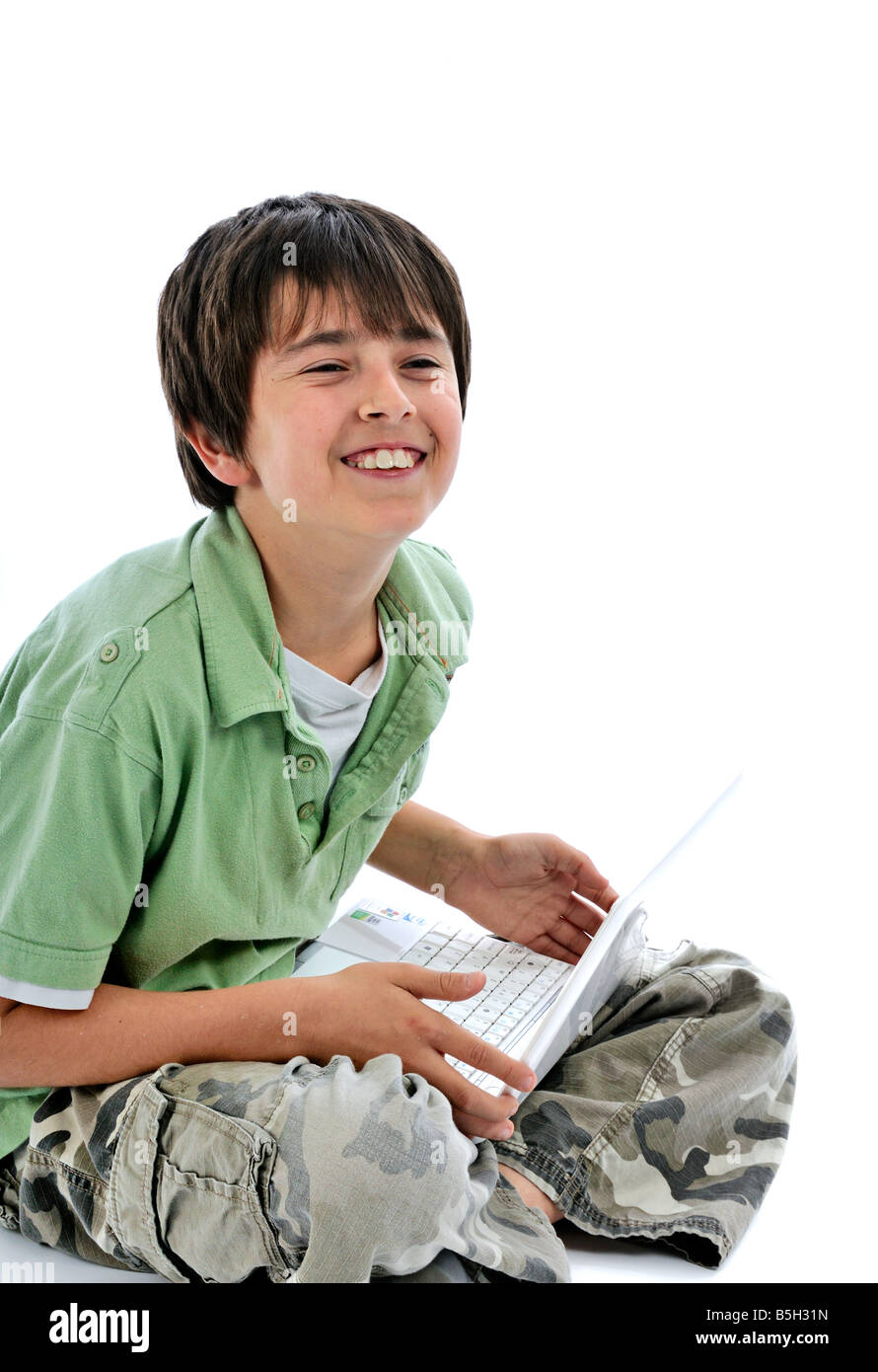 Young boy using an ASUS Eee PC laptop and smiling Stock Photo