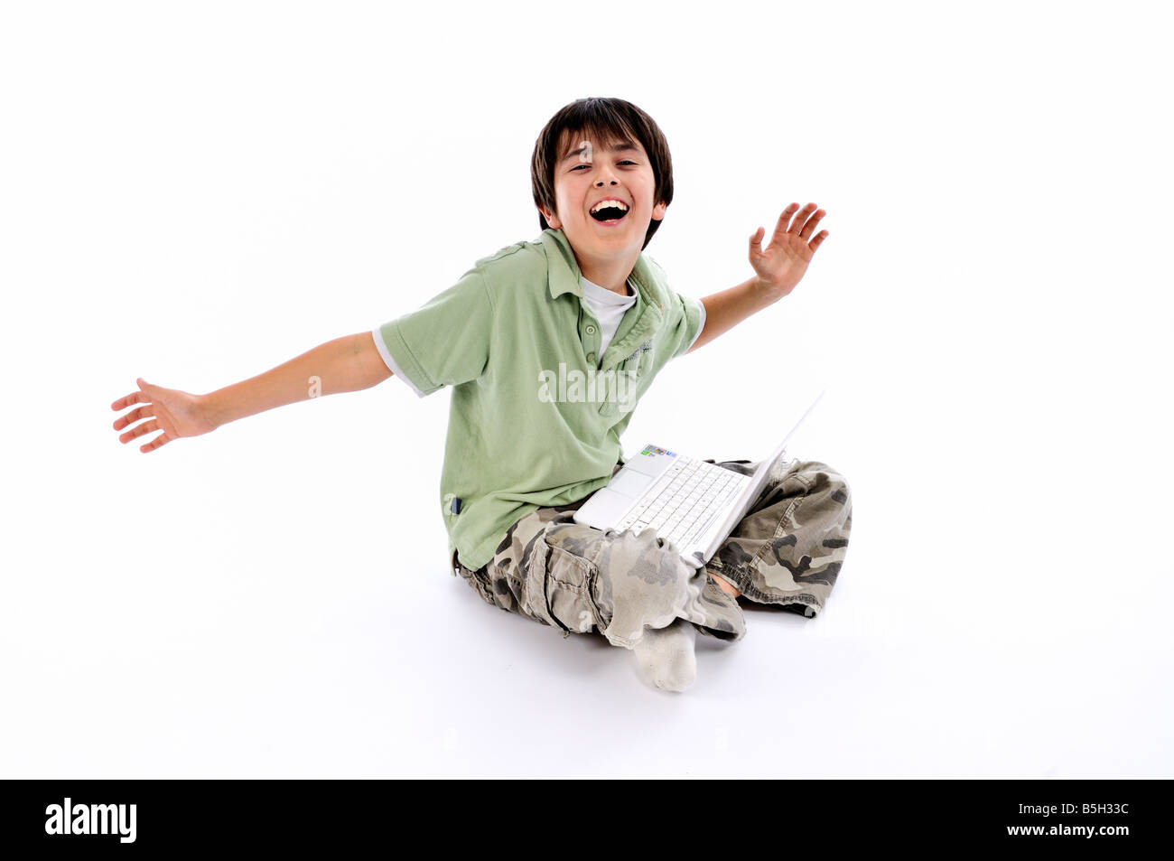 Young boy using an ASUS Eee PC laptop and laughing Stock Photo
