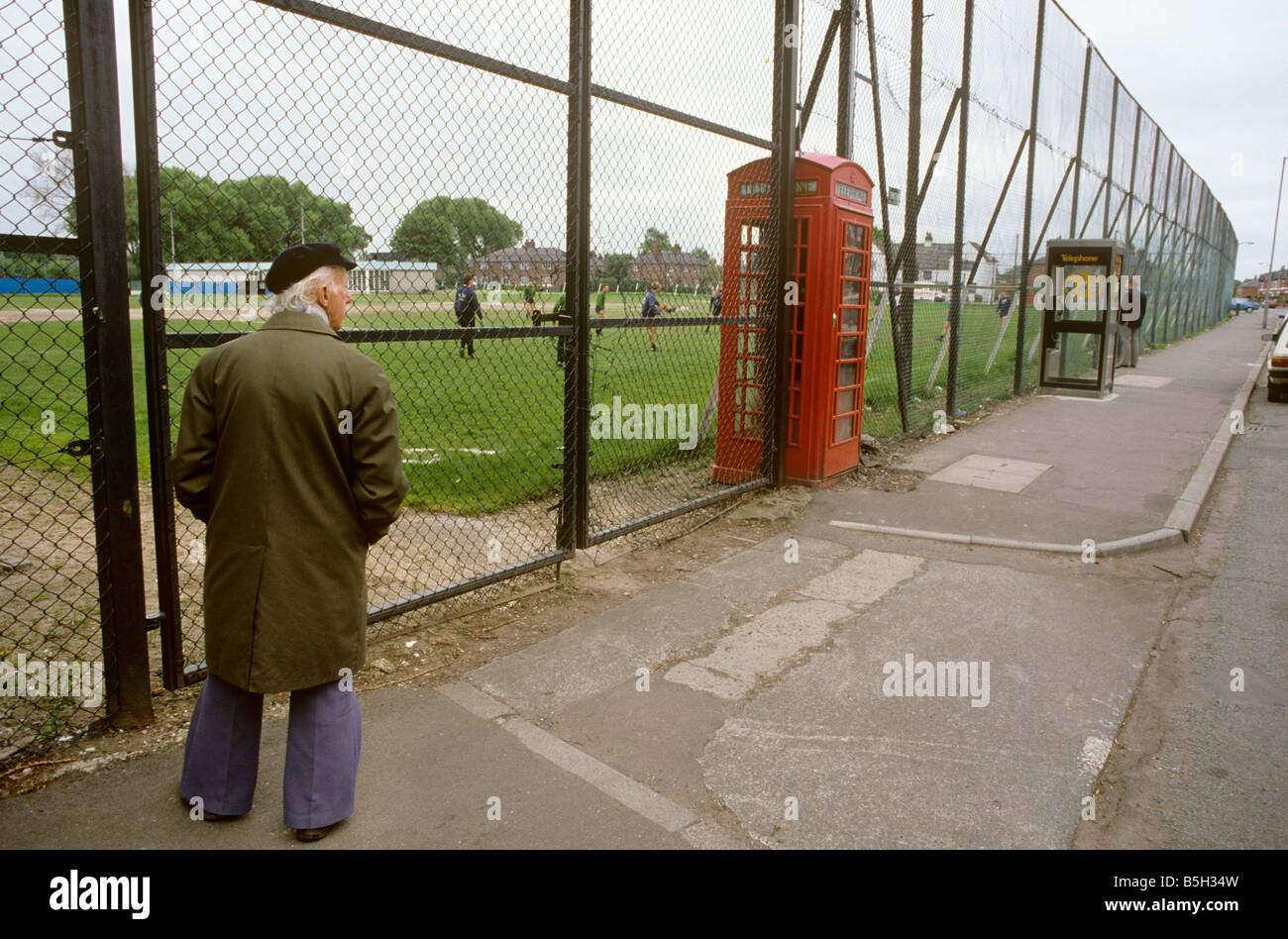 UK England Manchester Rusholme K6 and new KX100 Phone boxes in Manchester City football clubs Platt Lane Training Ground fence Stock Photo