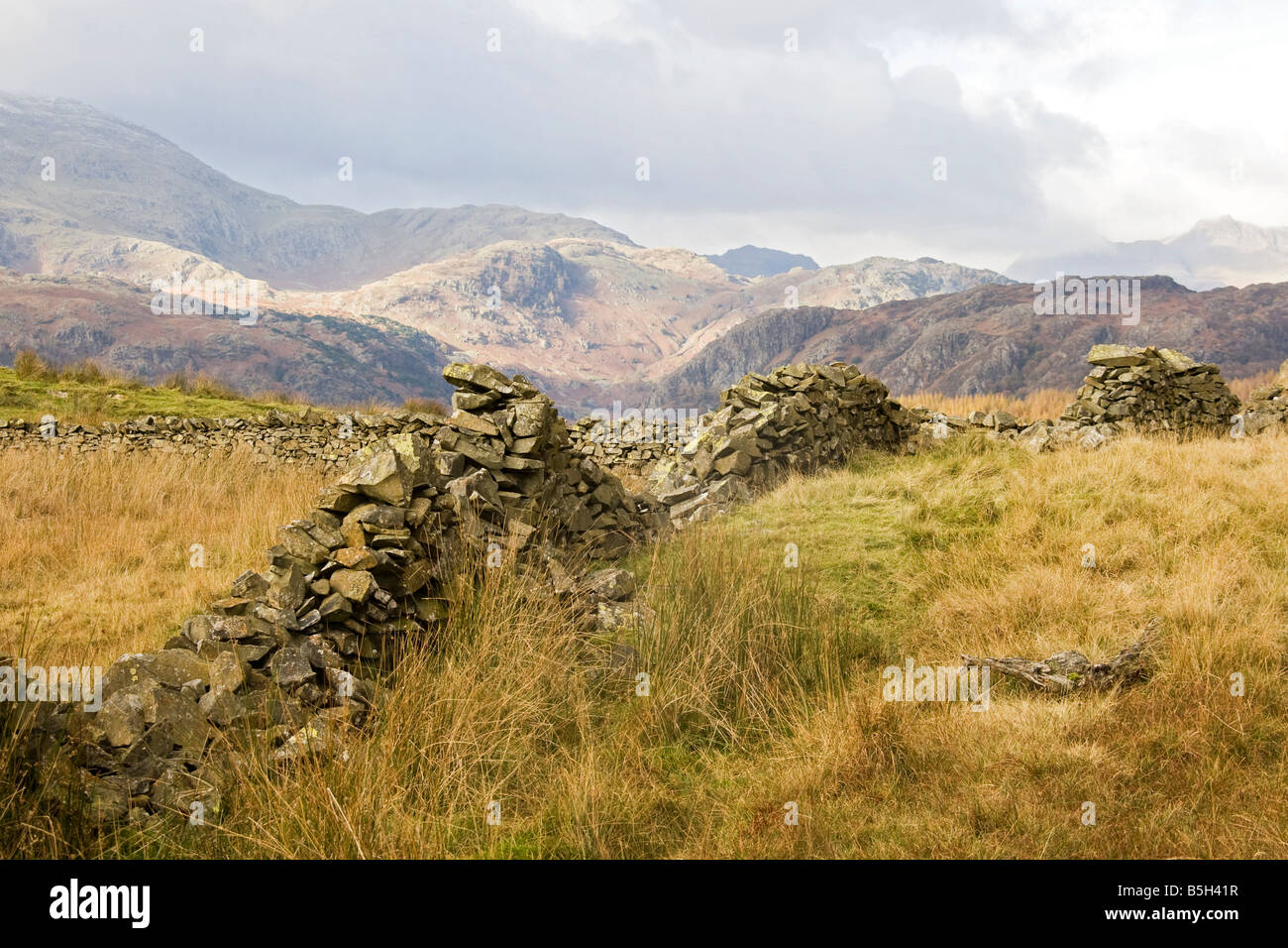 Stonewalls with mountains against cloudy sky . Stock Photo