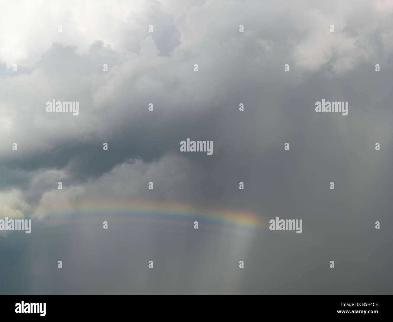 rainbow and dark stormy clouds Stock Photo - Alamy