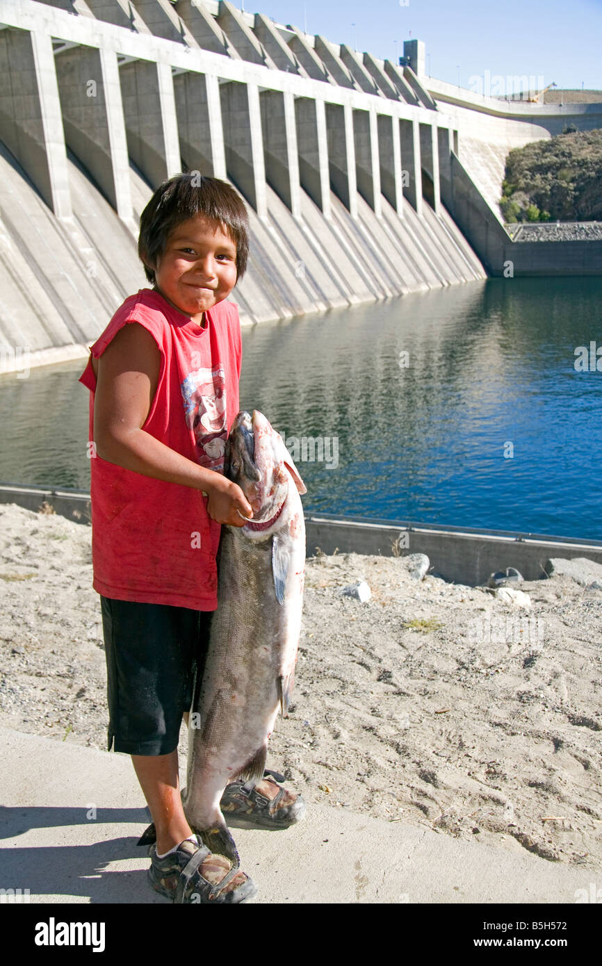 Colville Native American Indian boy with large Chinook Salmon at Chief Joseph Dam in Washington Stock Photo
