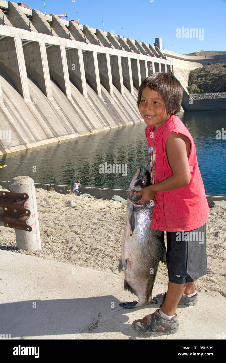 Colville Tribe Native American Indian boy holding a Chinook Salmon at Chief Joseph Dam in Washington Stock Photo