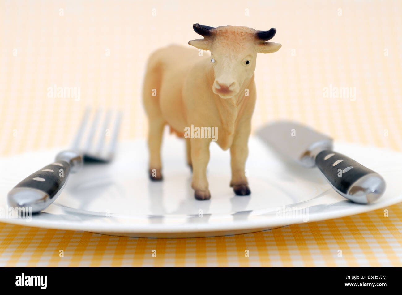 toy cow upon a plate, symbol for vegetarian food Stock Photo
