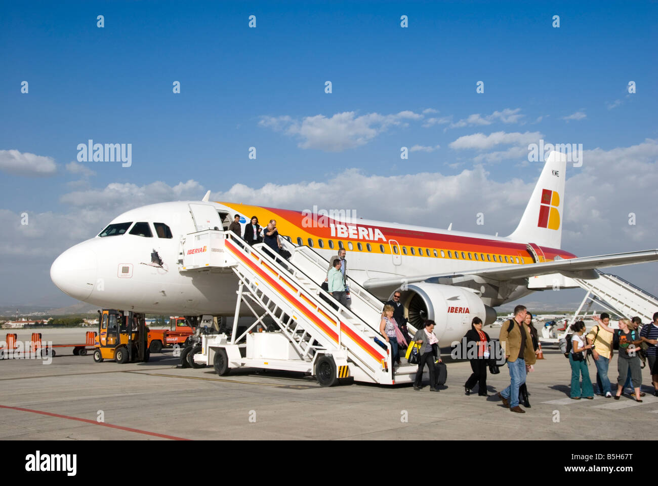 Passengers leaving Iberian aircraft on runway at Granada airport. Spain Stock Photo