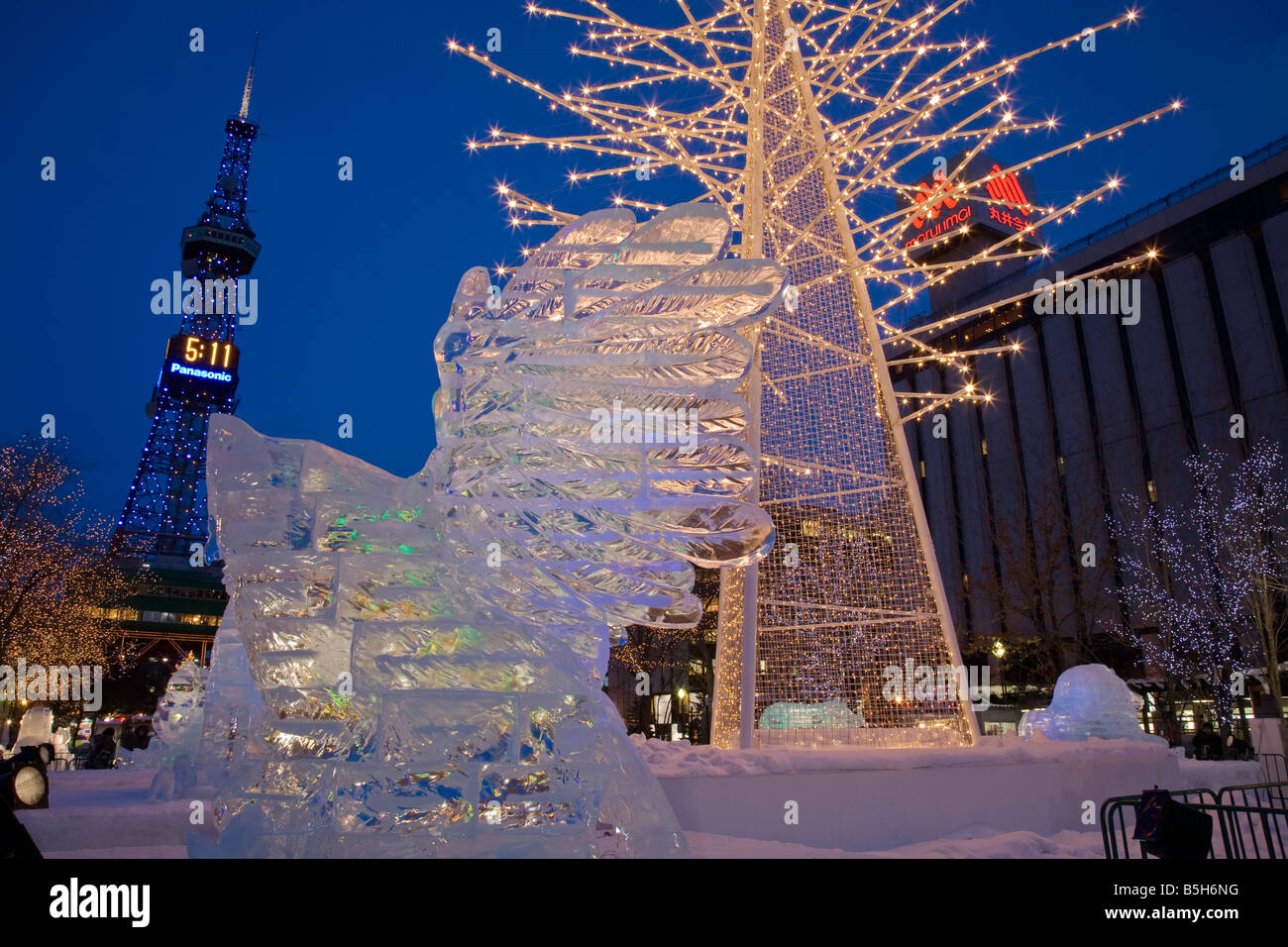 Sapporo Japan Sapporo TV Tower stands above the annual Snow Festival in Odori Park night scene with ice scupltures and lights Stock Photo