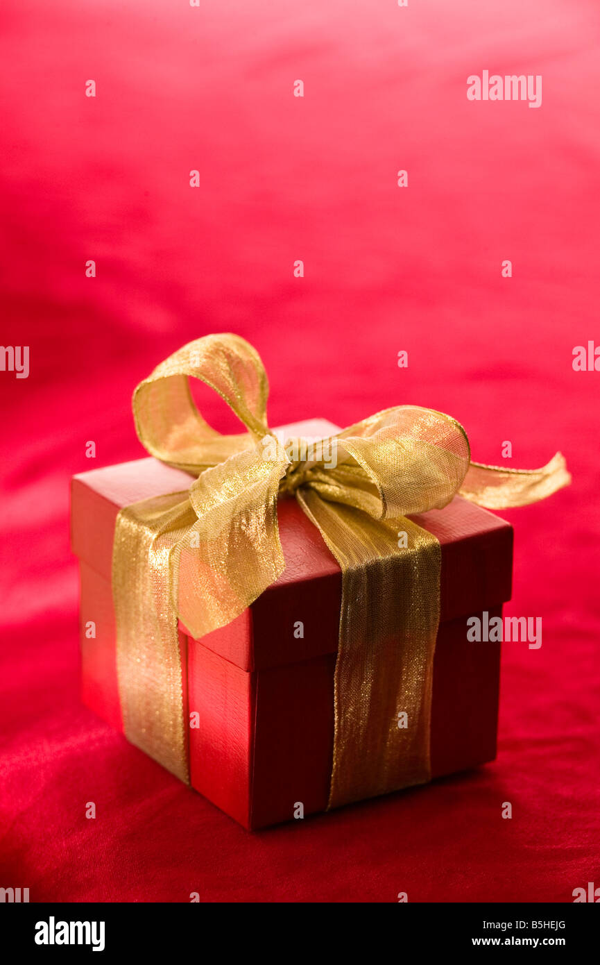 red gift box with a metallic gold ribbon Stock Photo