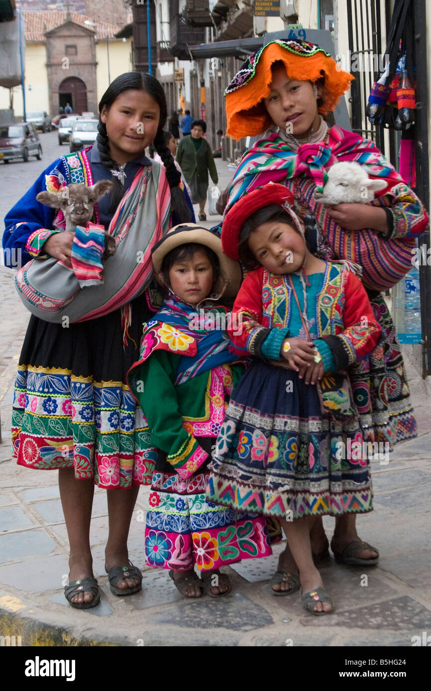 four peruvians girls in traditional dress on the streets of Cusco, Peru ...