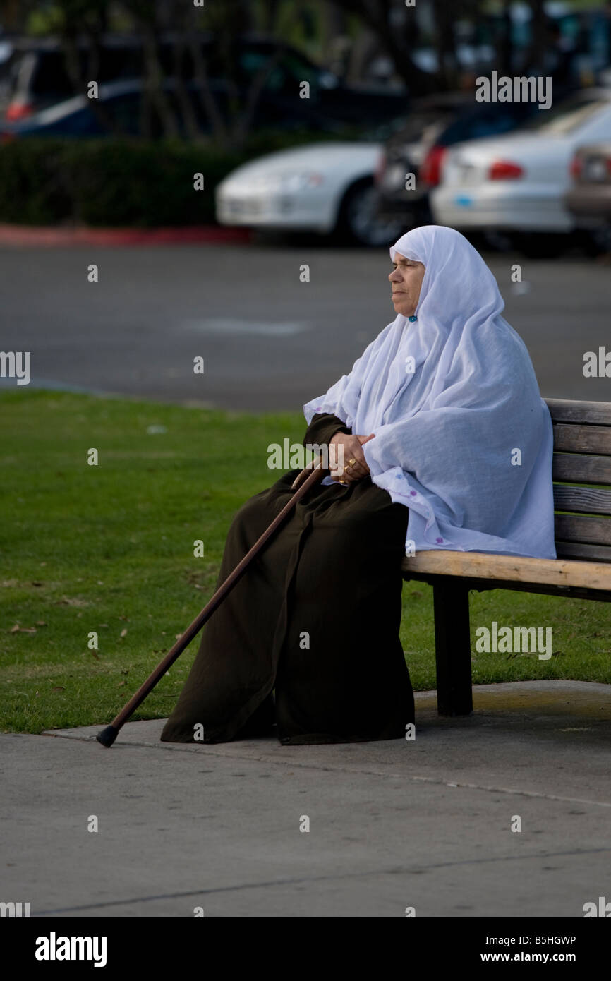 Older moslem woman on a park bench Stock Photo