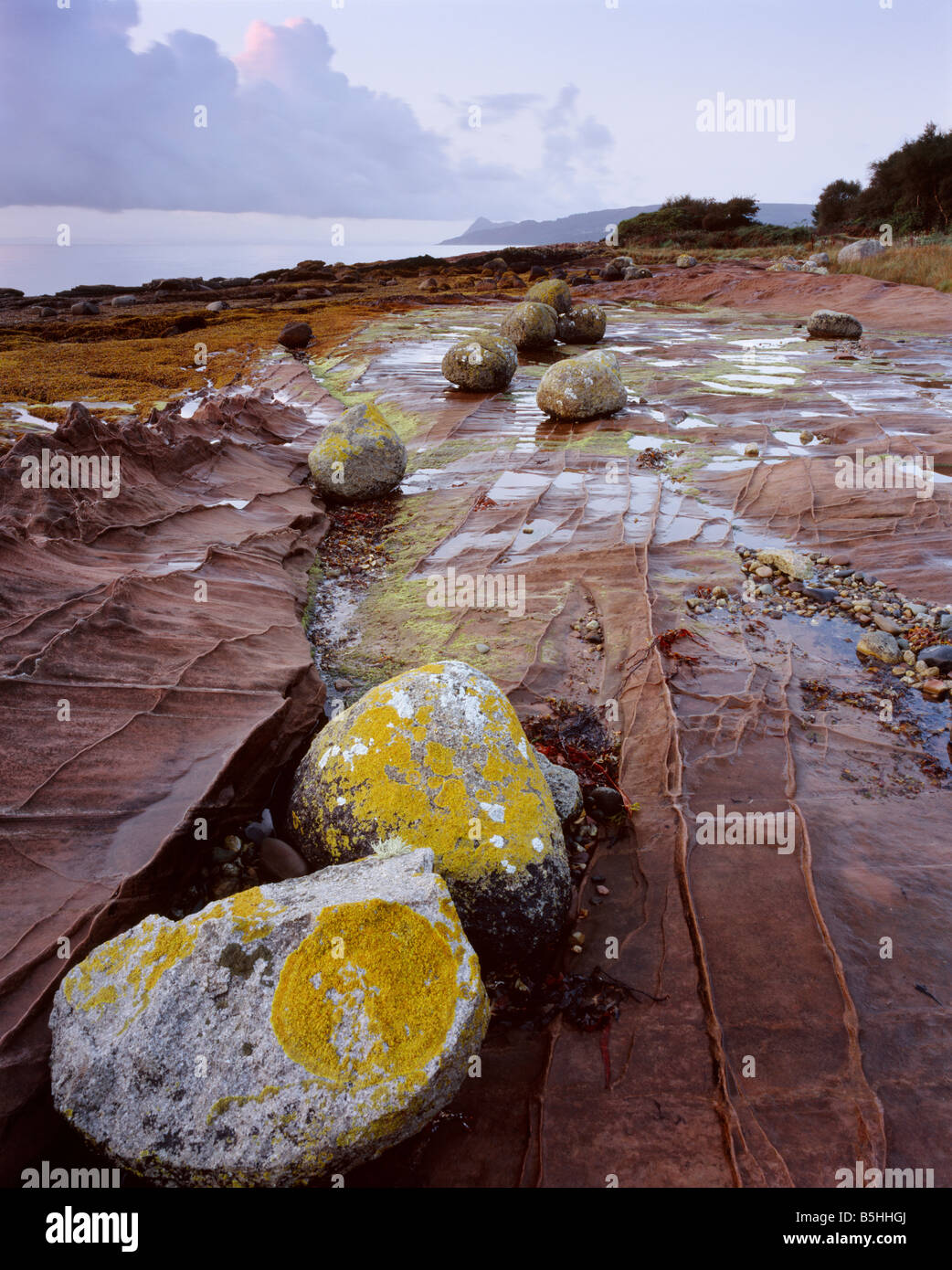 Glacial erratic boulders on sandstone bedrock Pirate's Cove near Corrie, Isle of Arran, North Aryshire, Scotland, UK. Stock Photo