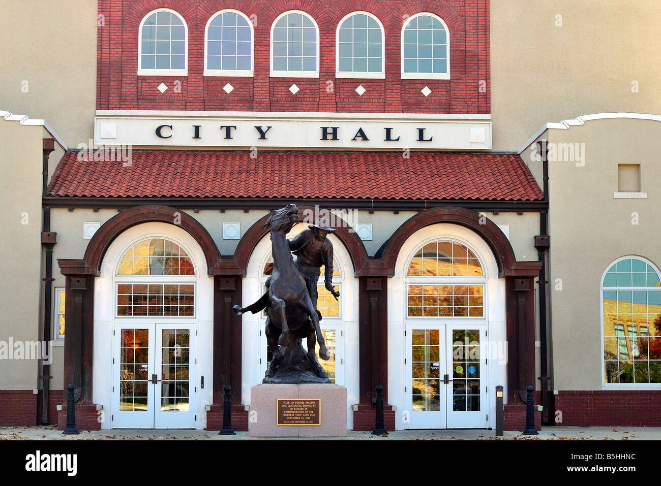 Ponca City City Hall with the Centennial Monument of a land run settler, in Ponca City, Oklahoma, USA. Stock Photo