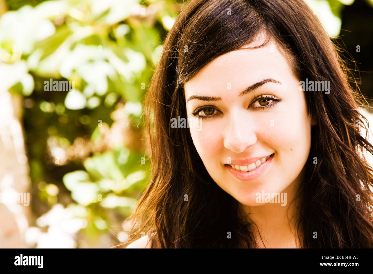 Smiling young woman staring at camera Stock Photo