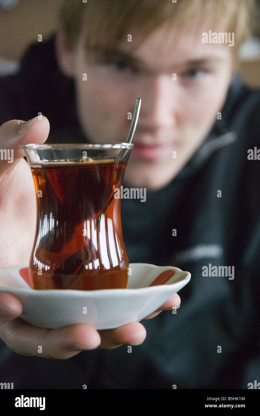 Turkish tea served in a traditional tulip-shaped glass with suacer and sugar cube. Stock Photo