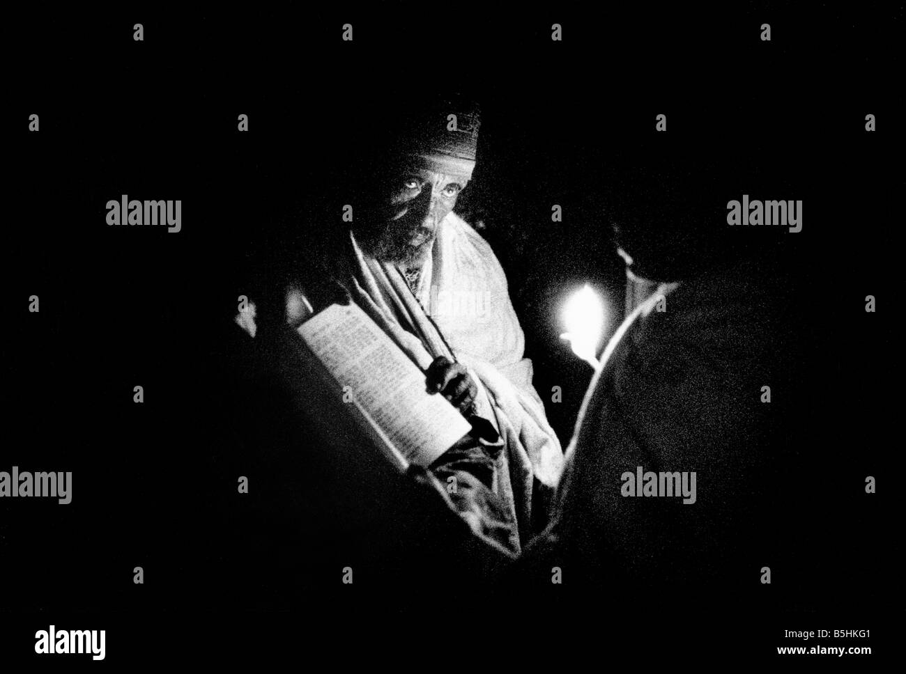 Ethiopian Orthodox monk reading the bible by candlelight at Lalibela, Ethiopia Stock Photo