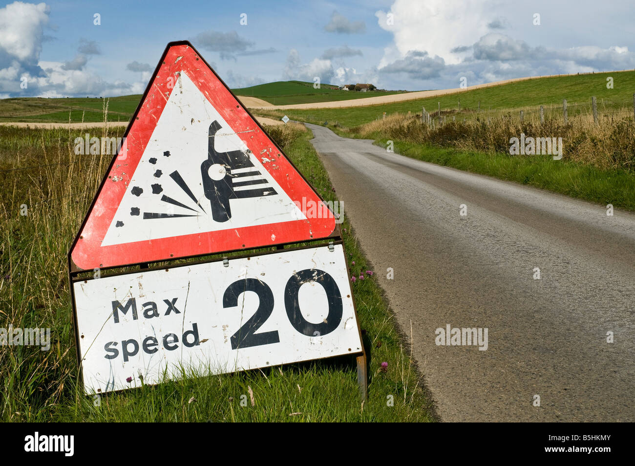 dh Roadsign ROAD UK Lose road chippings warning sign 20 mph max speed red triangle Stock Photo